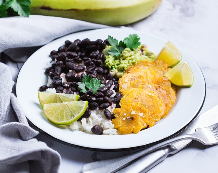 traditional-caribbean-food-rice-with-black-beans-tostones-fried-green-bananas-min