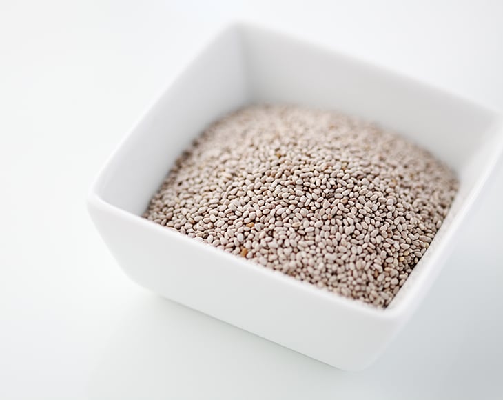 White chia seeds in a bowl against white background