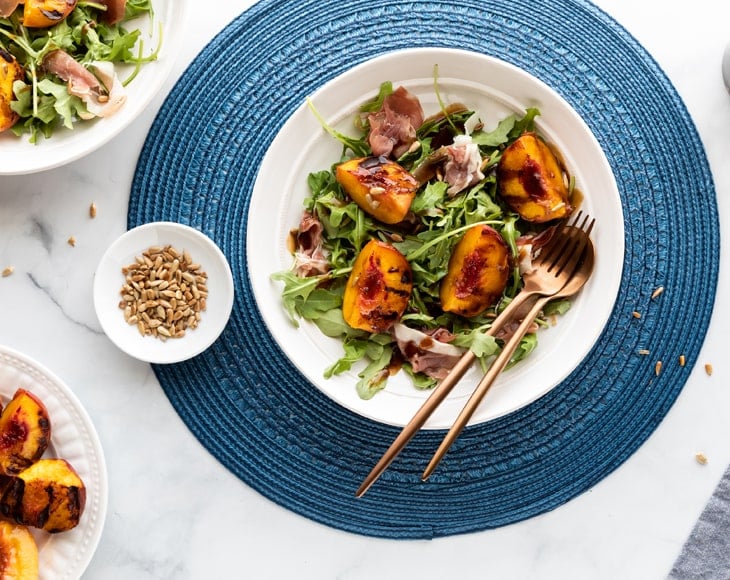 grilled-peach-and-arugula-salad-topped-with-organic-roasted-sunflower-seeds-min
