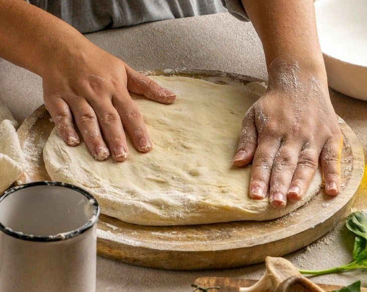 female-chef-stretching-pizza-dough-with-organic-italian-pizza-flour-min